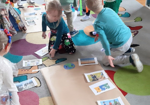 Dzieci wykonują plakaty w zespołach.